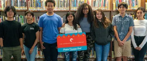 group of teens holding a giant library card
