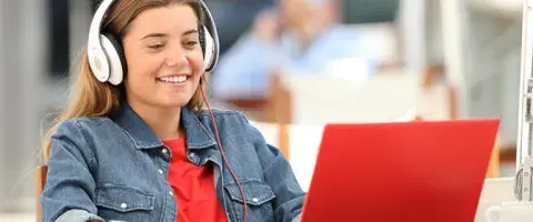 teen with headphones looking at a laptop
