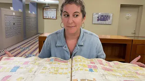 person sits behind large open book