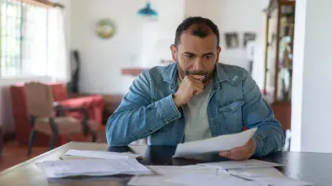 man sitting at a table looking at paperwork