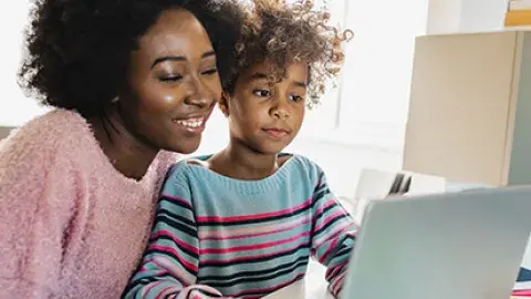 mother next to her child as she helps him with school work